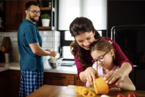 Food preparation with parents and child in the kitchen